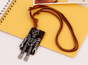 Detail of vintage robot pendant with silver metal texture and brown leather cord