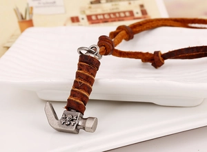 Macro shot of retro alloy claw hammer pendant with skull carving and leather cord
