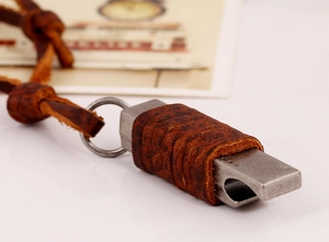 Gros plan d'un collier sifflet rétro avec revêtement en cuir marron et cordon tressé