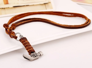 Detail of hammer pendant with skull motif and leather wrap on brown leather cord necklace