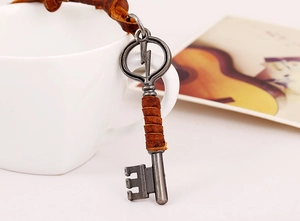 Macro view of vintage alloy key pendant with lightning logo and brown leather wrap