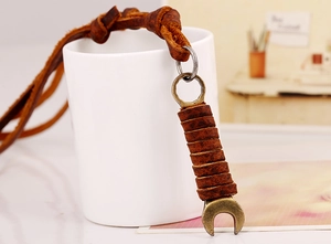 Detail of vintage bronze wrench pendant with dark brown genuine leather wrap