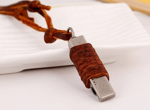 Vue macro d'un pendentif vintage en argent avec ruban de cuir marron sur plateau