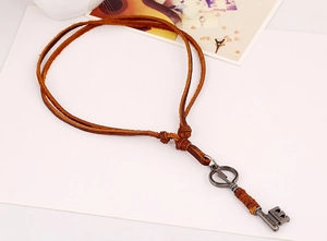 Macro detail of retro leather necklace with lightning key pendant and silver metal