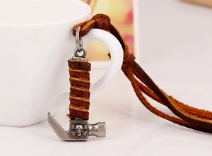 Detailed close-up of alloy hammer pendant with skull motif and brown leather cord