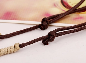 Detail of hand-woven dark brown wax cord necklace with beige adjustable knot detail