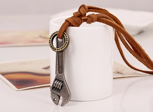 Macro detail of industrial wrench pendant on a brown leather cord hung on a white cup