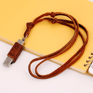 Collier industriel vintage avec cordon en cuir et métal vieilli sur un carnet jaune