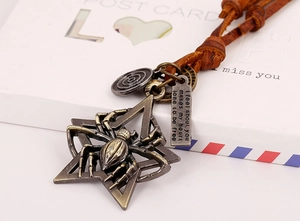 Dettaglio del ciondolo vintage ragno stella con tag inciso su cordoncino in pelle