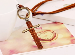 Macro detail of cross sword pendant with genuine leather wrap and bronze alloy finish