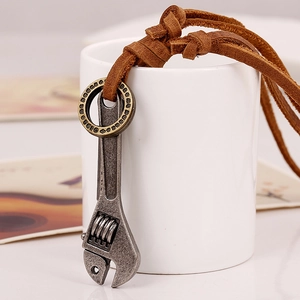 Retro industrial wrench pendant with brown leather cord shown hanging on a cup