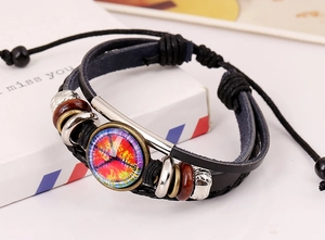 Macro detail of multilayer braided leather bracelet with vintage glass charm and wood beads