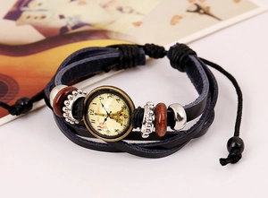 Macro detail of multilayer woven leather bracelet featuring Eiffel Tower clock ornament