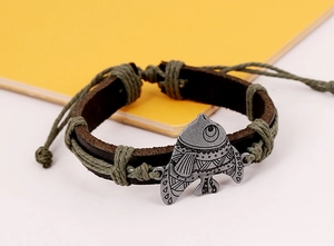 Détail d'un bracelet en cuir artisanal avec cordon vert et breloque en forme de poisson