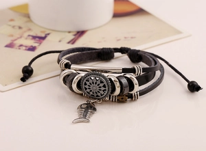 Detailaufnahme eines mehrlagigen Lederarmbands mit Fischgräten-Anhänger und Stern-Dekor