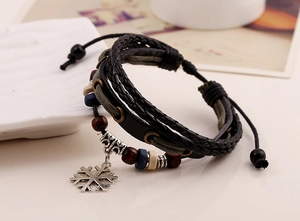 Dettaglio del bracciale multistrato in pelle intrecciata con ciondolo a fiocco di neve