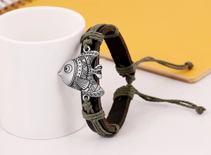 Détail d'un bracelet en cuir fait main avec pendentif poisson rétro et cordon ajustable