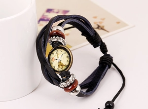 Macro view of vintage leather multilayer bracelet featuring Eiffel Tower clock charm detail