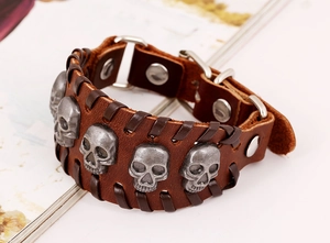 Detail of punk leather bracelet with vintage skull studs and woven cord edges