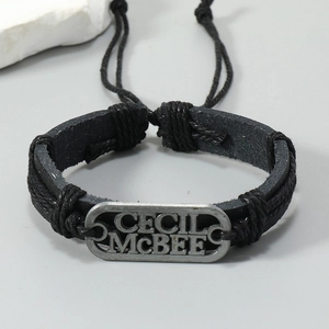 Vue détaillée du bracelet en cuir tressé noir avec plaque métallique vintage