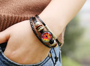 Detail of multi-layer leather bracelet with wooden beads and peace sign glass charm