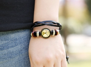 Detail of multi-layer leather bracelet with Eiffel Tower clock charm and wooden beads