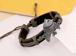 Vue détaillée du bracelet en cuir tressé avec un pendentif poisson en métal rétro