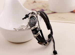 Details eines Vintage-Lederarmbands mit Fischgräten- und Sonnenanhänger in Silber