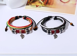 Detail of multi-layer leather bracelets with leaf pendants and woven colorful ropes