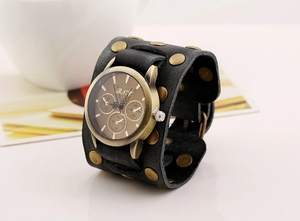 Detail of vintage wide black leather men's bracelet watch with bronze rivets
