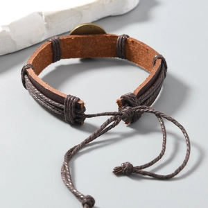 Detail eines gewebten PU-Lederarmbands mit Retro-Messingmedaillon und Kordelzug