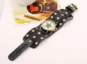 Macro view of wide black leather cuff watch with bronze rivets and star dial design