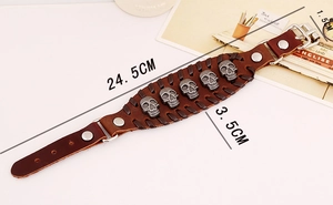 Detail view of brown leather punk bracelet featuring five silver metal skulls and weaving