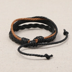Retro multi-layer braided leather bracelet with adjustable knot on beige linen fabric