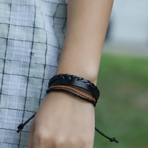 Detail of multi-layer hand-woven leather bracelet set on wrist with adjustable cord