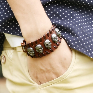 Retro punk brown leather bracelet with silver skull rivets and woven edges on wrist