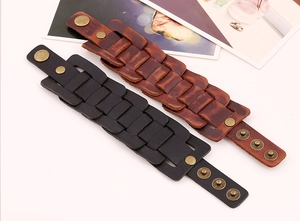 Detail view of vintage multi-layer leather bracelets with adjustable brass snap buttons