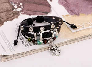 Dettaglio del bracciale punk in pelle con borchie, perline e ciondolo a croce teschio