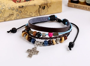 Close-up of multi-layer leather bracelet with wooden beads and silver cross pendant