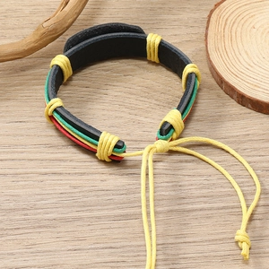 Detailed macro of handmade leather bracelet with Jamaican red yellow green woven cords
