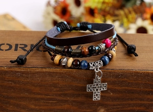 Detail of multi-layer leather bracelet with wooden beads and silver cross pendant