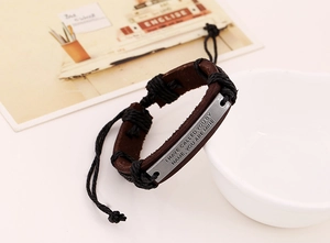 Detailed shot of retro leather bracelet with engraved metal plate and adjustable cord