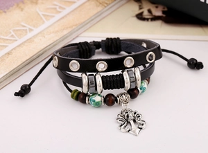 Dettaglio bracciale punk in pelle con teschio, perline di legno e strati intrecciati
