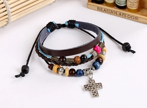 Detail of multi-layer leather bracelet with wooden beads and silver cross pendant