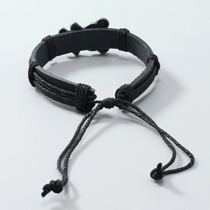 Detail eines geflochtenen Lederarmbands mit Bärenanhänger und verstellbarem Kordelzugverschluss