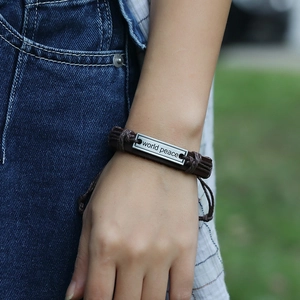 Macro shot of world peace engraving on a braided leather wrap bracelet for men and women