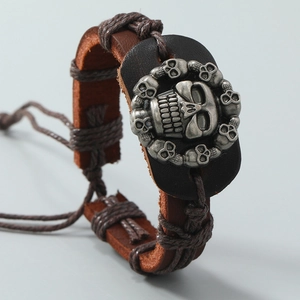 Dettaglio macro del bracciale da uomo in pelle con teschio vintage e corda intrecciata