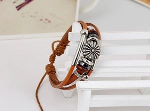 Detail of multilayer brown leather bracelet with silver sunflower charms and metal beads
