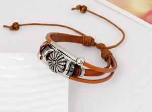 Macro shot of multilayer brown leather bracelet with floral pendants and wood beads