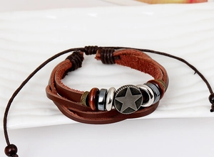Macro detail of multi-layer woven leather bracelet with star charm and bead accents